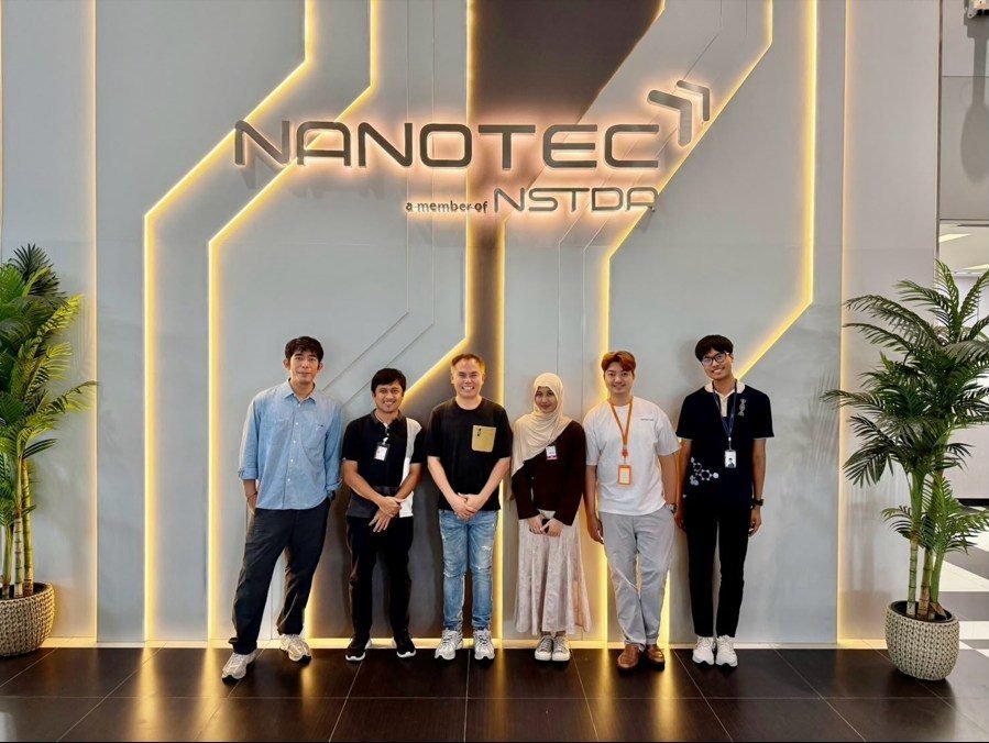 Team members in front of the NANOTEC sign during the laboratory visit